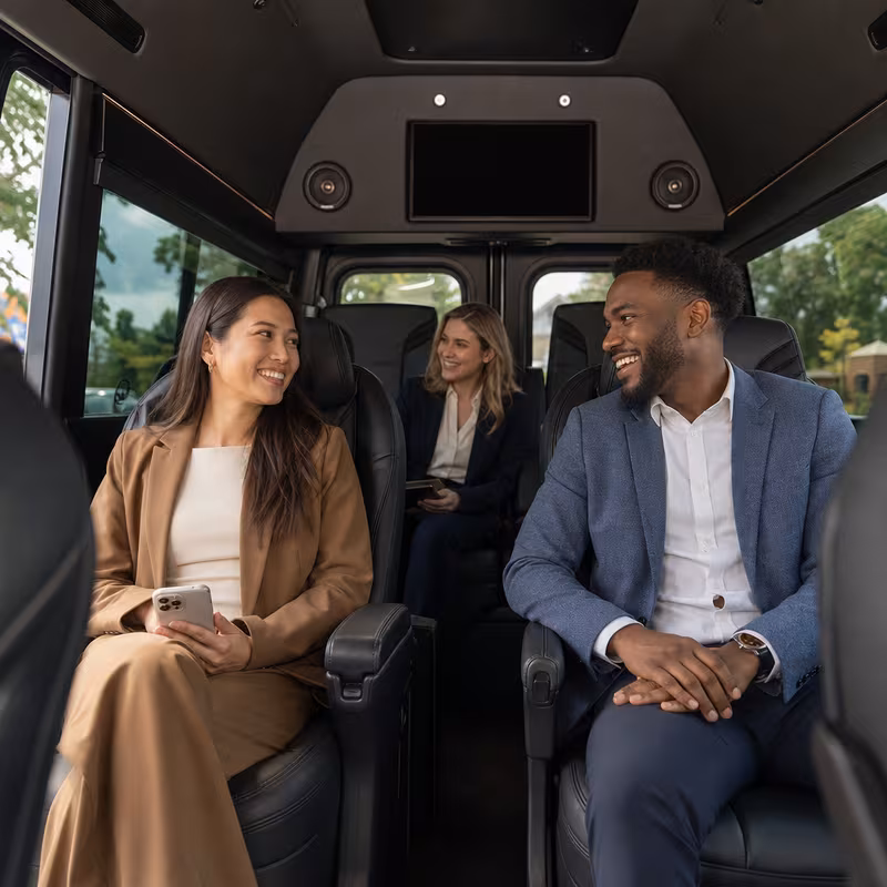 Group boarding a white charter bus for Corporate Transportation transportation in Indianapolis