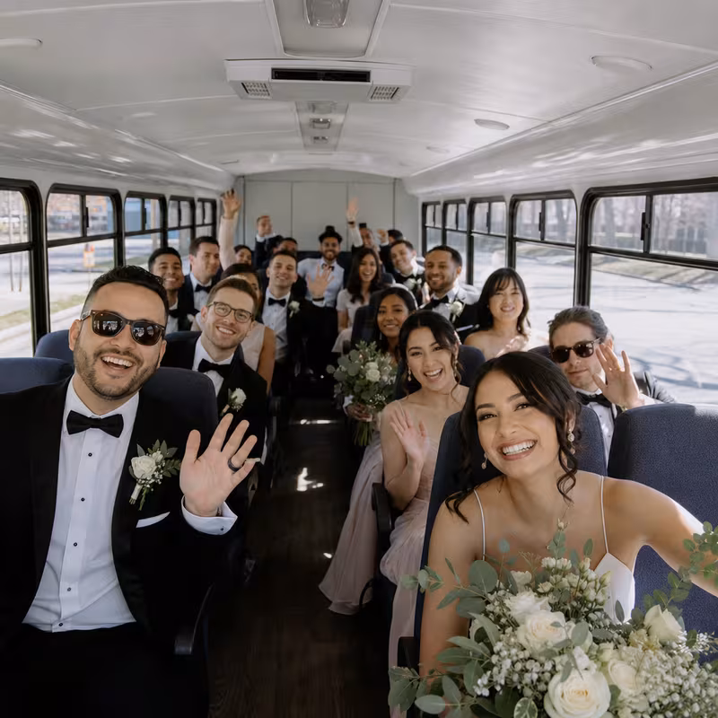 Group boarding a white charter bus for Wedding Transportation transportation in Indianapolis